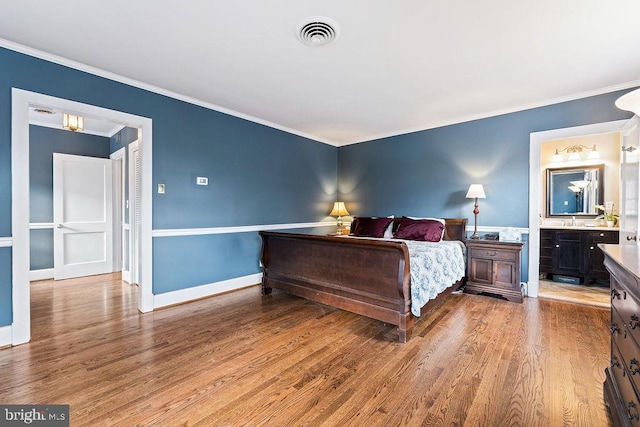 bedroom with baseboards, wood finished floors, visible vents, and ornamental molding