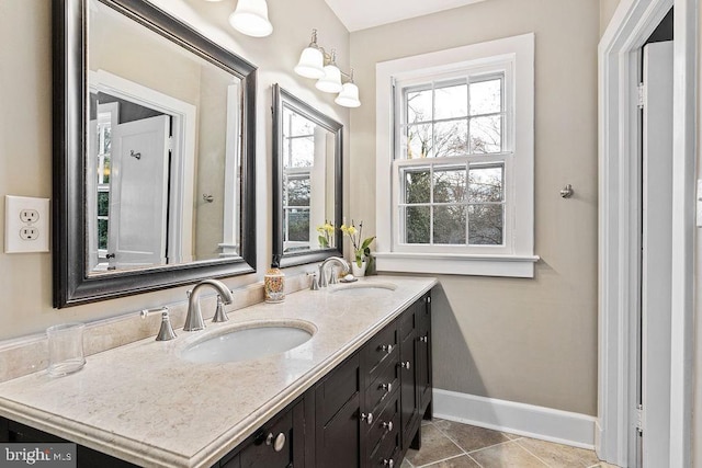 bathroom featuring double vanity, baseboards, tile patterned floors, and a sink