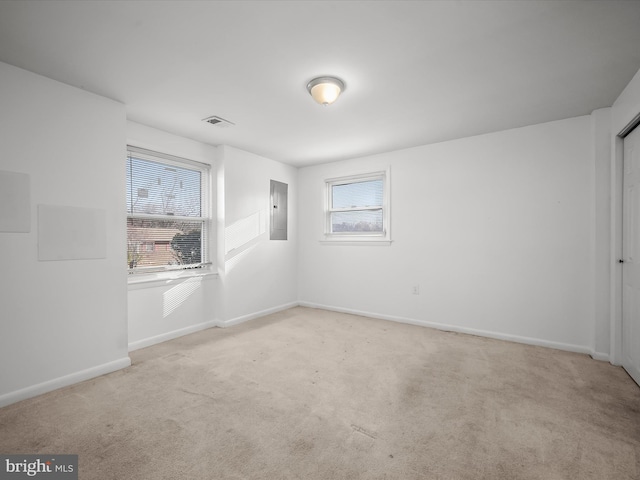 unfurnished room with electric panel, baseboards, and carpet flooring