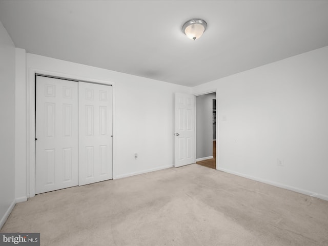 unfurnished bedroom featuring a closet, baseboards, and carpet