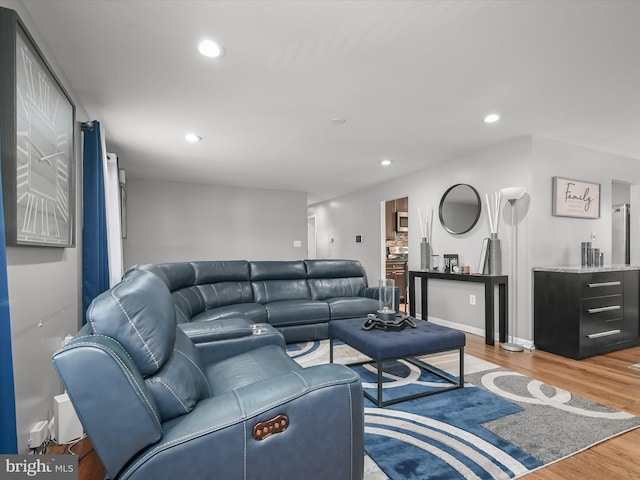 living room with recessed lighting, baseboards, and wood finished floors