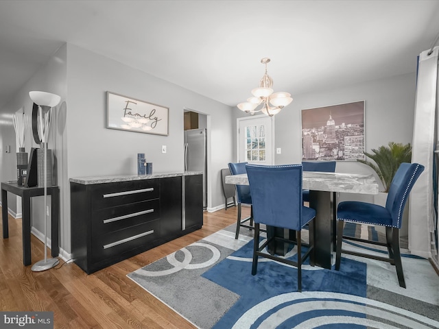 dining room featuring baseboards, an inviting chandelier, and wood finished floors