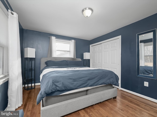 bedroom with a closet, baseboards, and wood finished floors