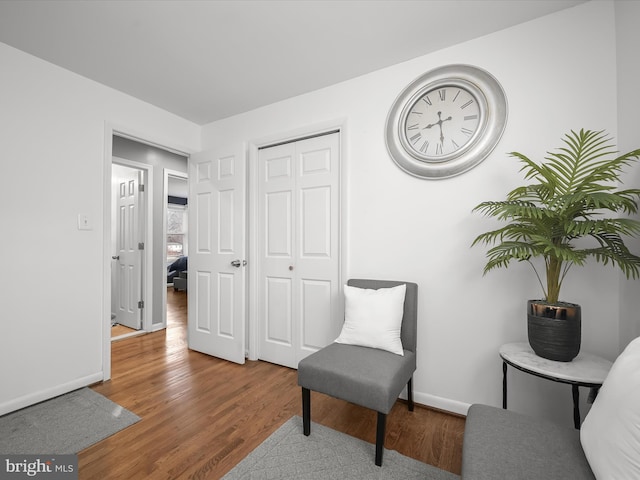 living area featuring baseboards and wood finished floors