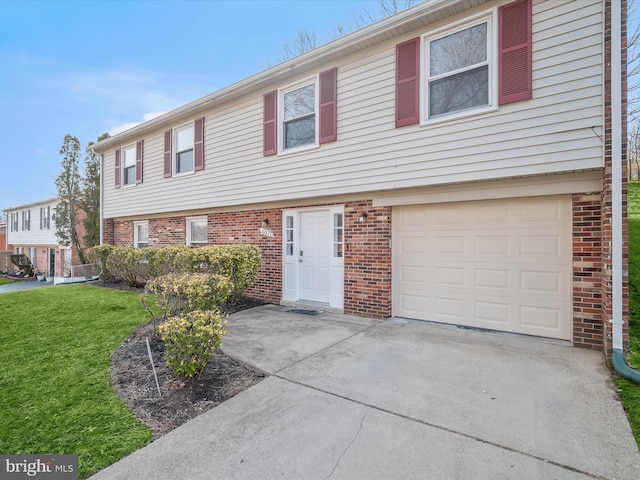 view of front of home featuring a front yard, an attached garage, brick siding, and driveway