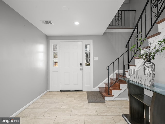 entrance foyer with visible vents, stairs, and baseboards