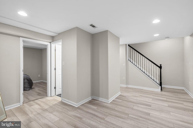 interior space featuring stairway, baseboards, visible vents, and light wood-type flooring