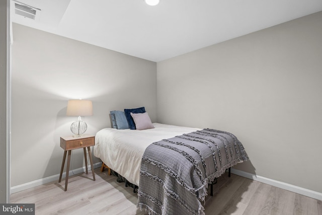 bedroom featuring wood finished floors, visible vents, and baseboards