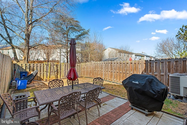 view of patio featuring area for grilling, outdoor dining area, cooling unit, and a fenced backyard