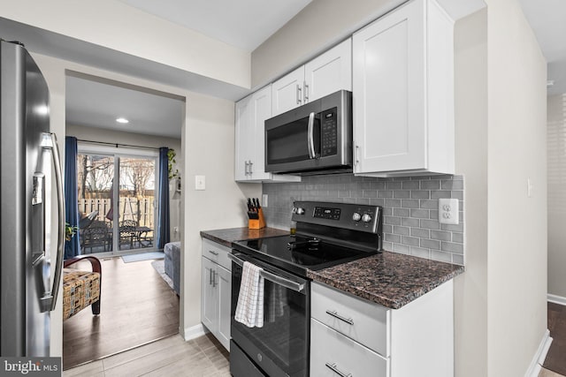 kitchen featuring decorative backsplash, dark stone counters, white cabinets, and appliances with stainless steel finishes