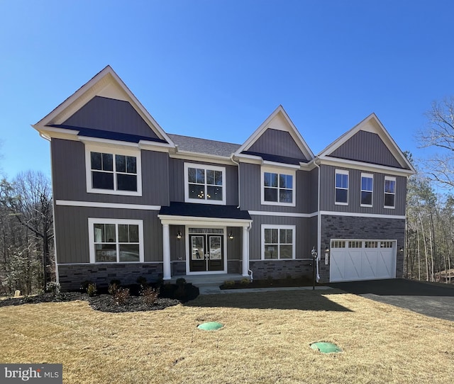 craftsman inspired home with a garage, stone siding, aphalt driveway, french doors, and a front yard