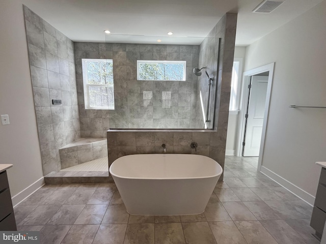 full bath featuring a walk in shower, visible vents, vanity, baseboards, and a soaking tub