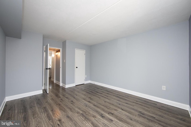 interior space with dark wood-type flooring and baseboards