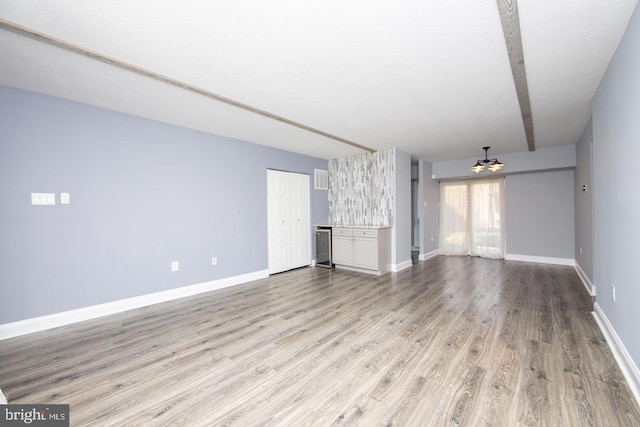 unfurnished living room with baseboards and light wood-style floors
