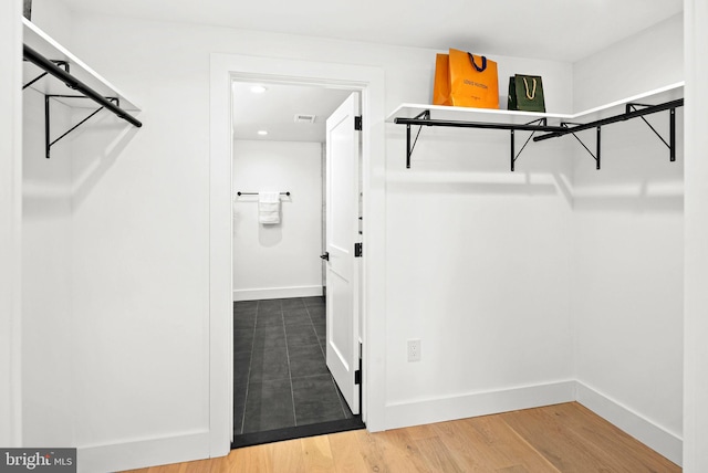 walk in closet with visible vents and wood finished floors