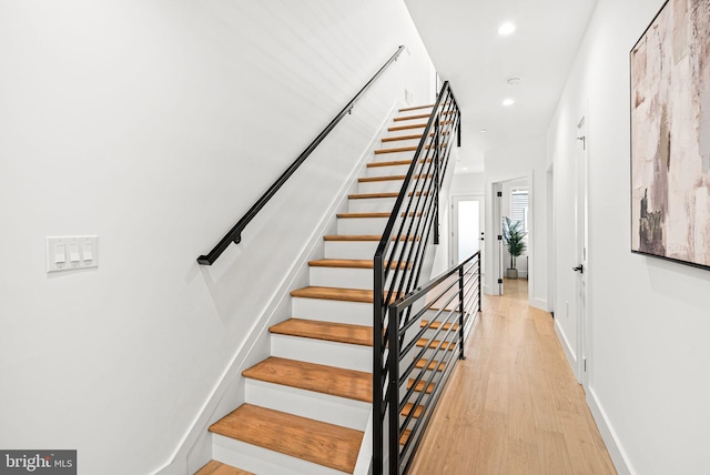 stairway featuring recessed lighting, baseboards, and wood finished floors