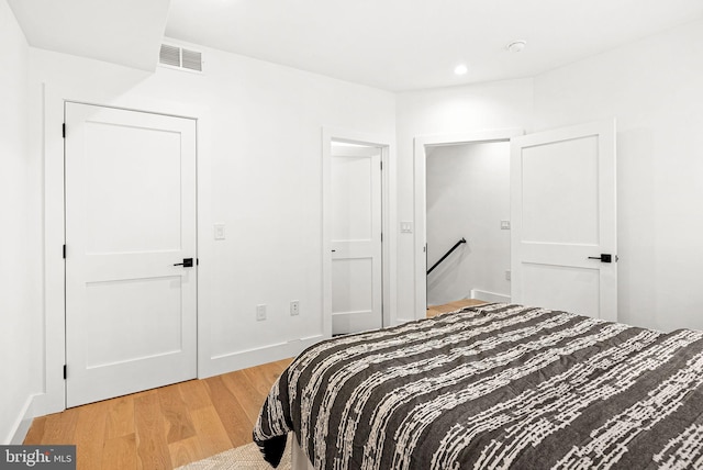 bedroom with light wood finished floors, visible vents, recessed lighting, and baseboards