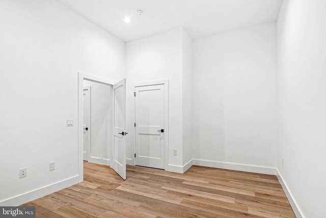 spare room with baseboards and light wood-style floors