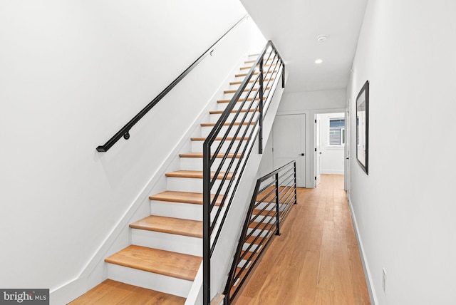 staircase with recessed lighting, baseboards, and wood finished floors