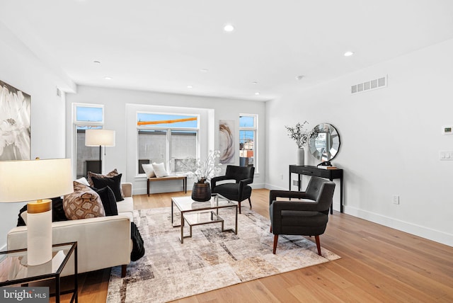 living area with recessed lighting, wood finished floors, visible vents, and a wealth of natural light