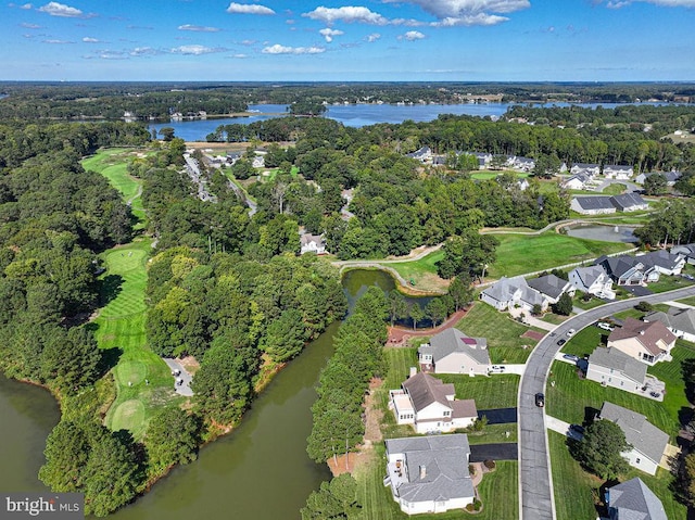 drone / aerial view with a water view, a forest view, view of golf course, and a residential view