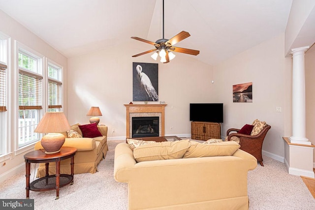 carpeted living area with vaulted ceiling, baseboards, and ornate columns