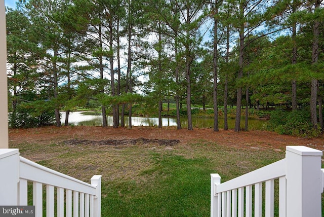 view of yard featuring a water view and fence