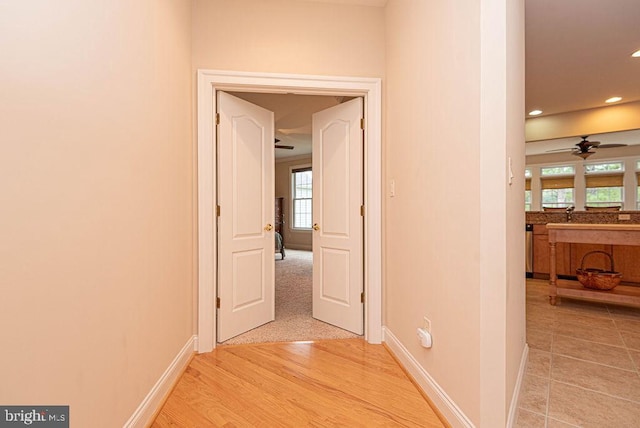 hallway featuring recessed lighting, light wood-style flooring, and baseboards