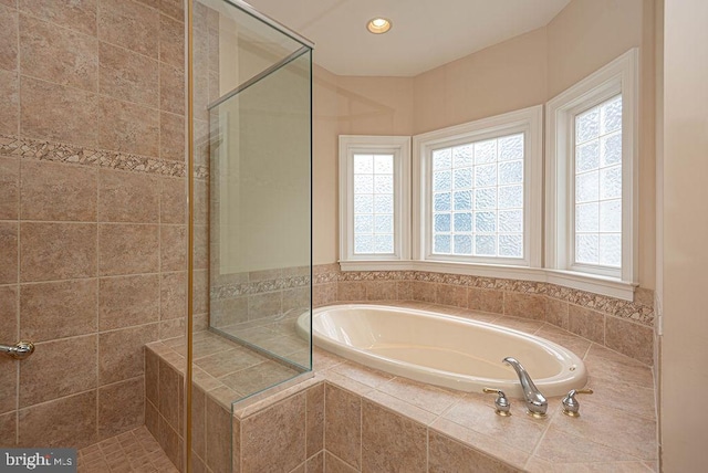 full bathroom with a stall shower, plenty of natural light, recessed lighting, and a bath