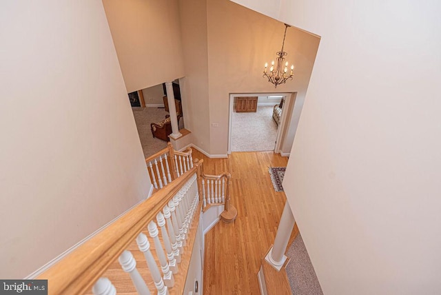 interior space with baseboards, a high ceiling, a chandelier, and wood finished floors