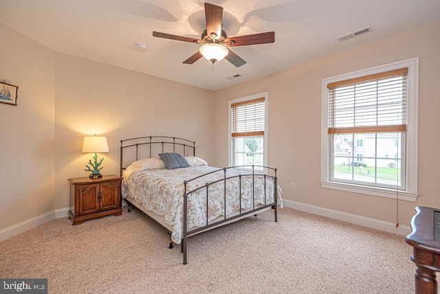 bedroom with baseboards, visible vents, carpet flooring, and multiple windows