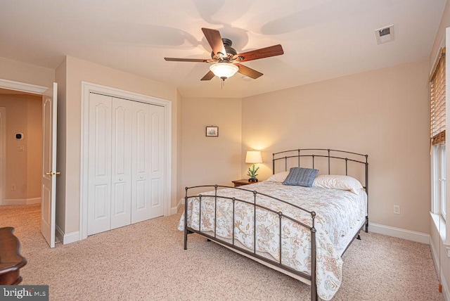 carpeted bedroom with ceiling fan, a closet, visible vents, and baseboards