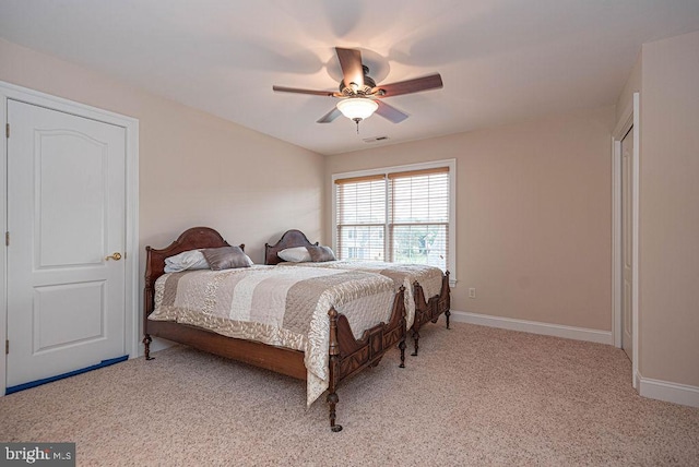 carpeted bedroom featuring baseboards, visible vents, and a ceiling fan