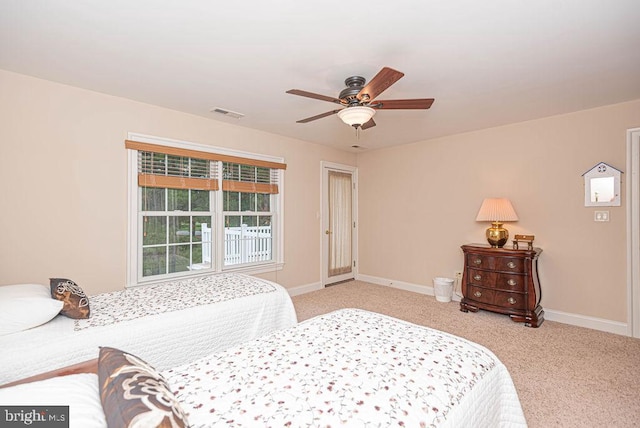 carpeted bedroom featuring ceiling fan, visible vents, and baseboards