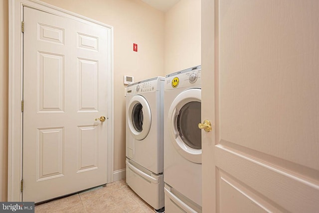 washroom featuring washing machine and dryer, laundry area, and light tile patterned flooring