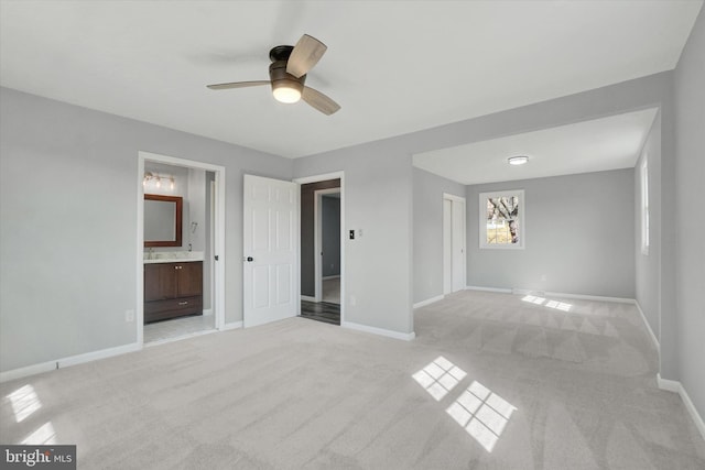 interior space with baseboards, light colored carpet, and ceiling fan