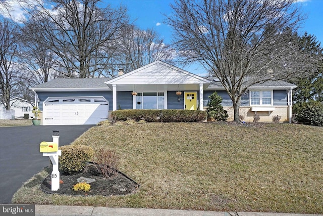 ranch-style home featuring a front yard, an attached garage, and driveway