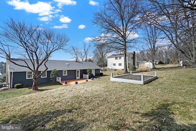 view of yard featuring a wooden deck and a vegetable garden