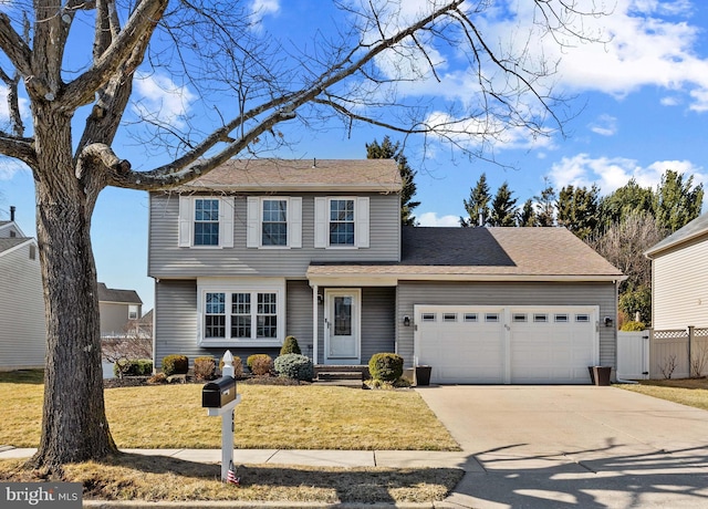 view of front of home with a front lawn, concrete driveway, fence, and an attached garage