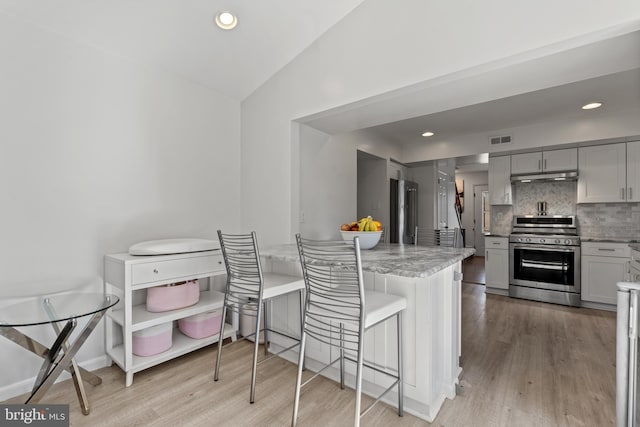 kitchen with stainless steel appliances, tasteful backsplash, visible vents, gray cabinetry, and under cabinet range hood