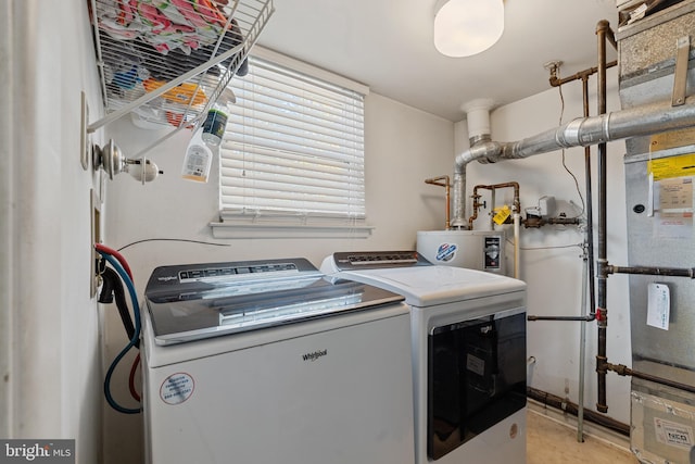 clothes washing area featuring laundry area, water heater, and washing machine and clothes dryer