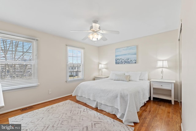 bedroom with visible vents, ceiling fan, baseboards, and wood finished floors