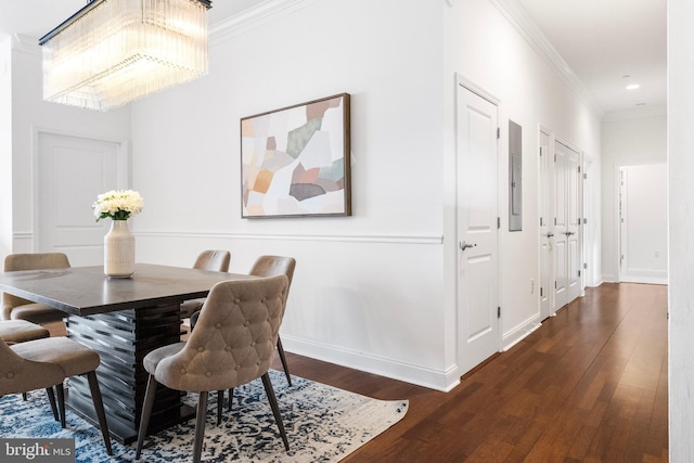 dining room featuring baseboards, wood finished floors, and crown molding