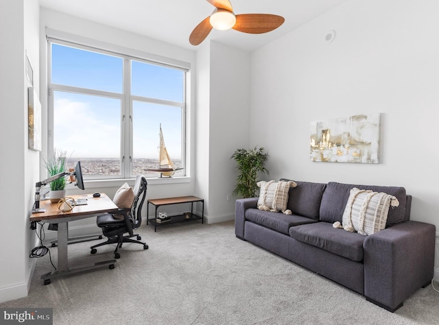 carpeted home office with ceiling fan and baseboards