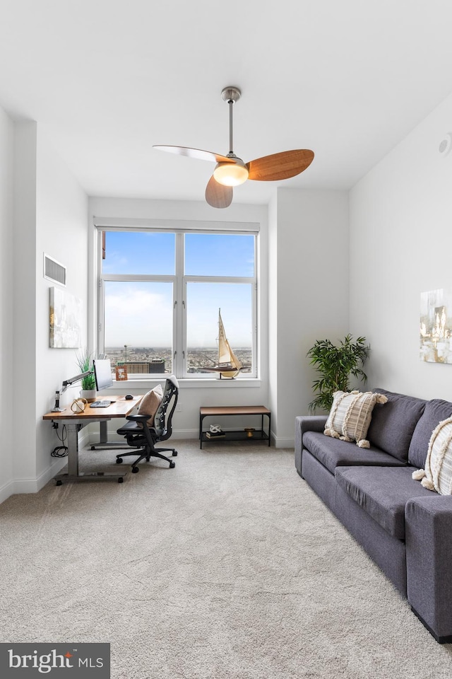 carpeted home office with a ceiling fan, visible vents, and baseboards