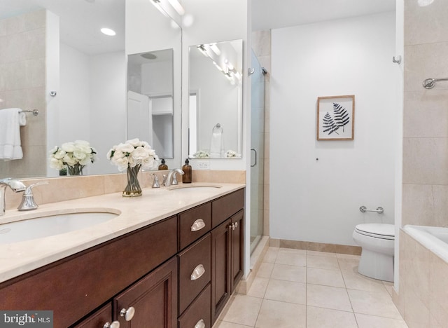 full bath with double vanity, tiled shower, tile patterned flooring, and a sink