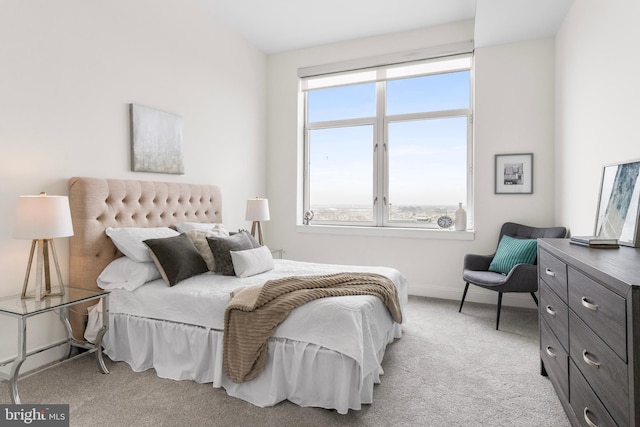 bedroom with baseboards and light colored carpet