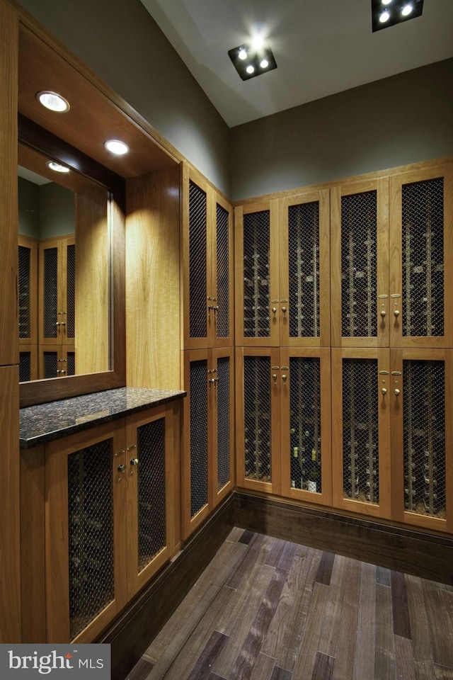 wine area with dark wood-type flooring and recessed lighting