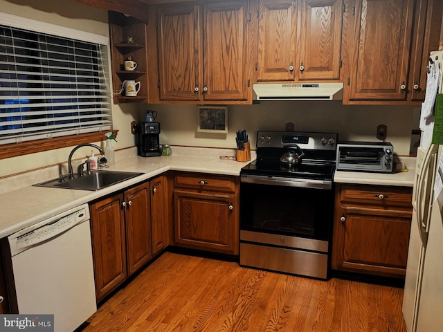 kitchen with white appliances, a toaster, ventilation hood, light countertops, and a sink