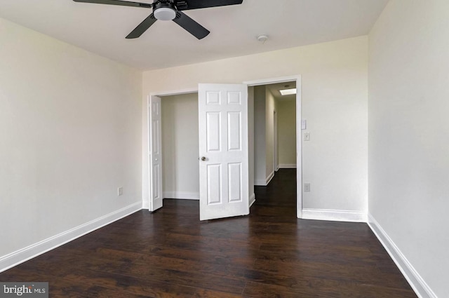 unfurnished bedroom featuring a ceiling fan, baseboards, and dark wood-style flooring